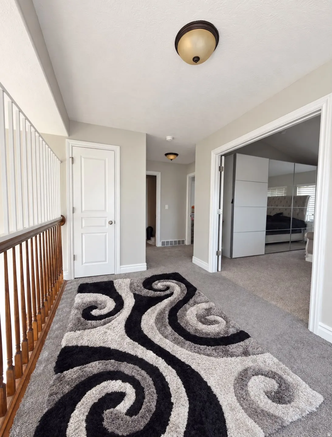 Carpeted hallway with painted walls, white doors, and recessed ceiling lights