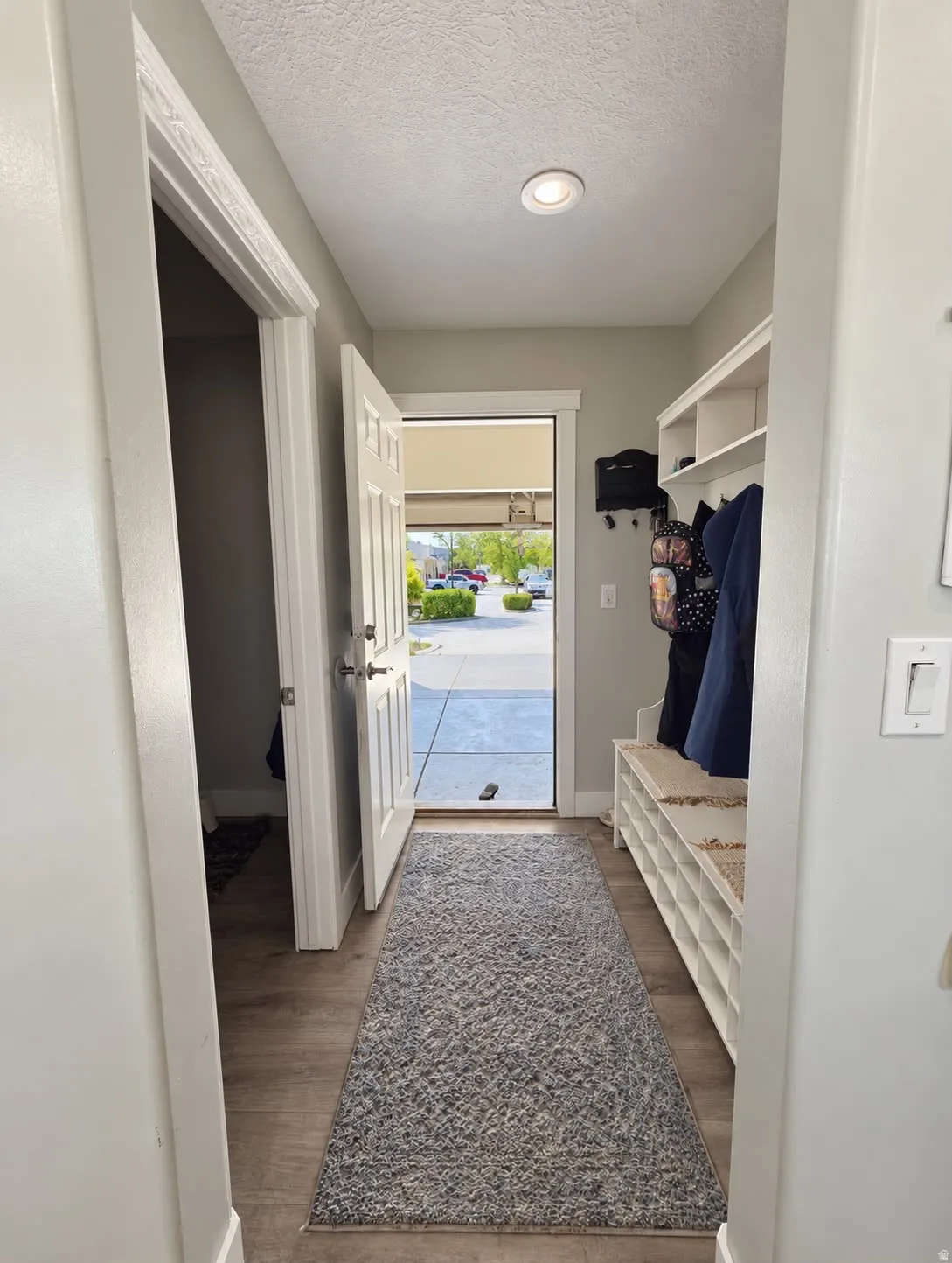 Entryway featuring wood-finish flooring, recessed lighting, and a built-in storage bench with shelving