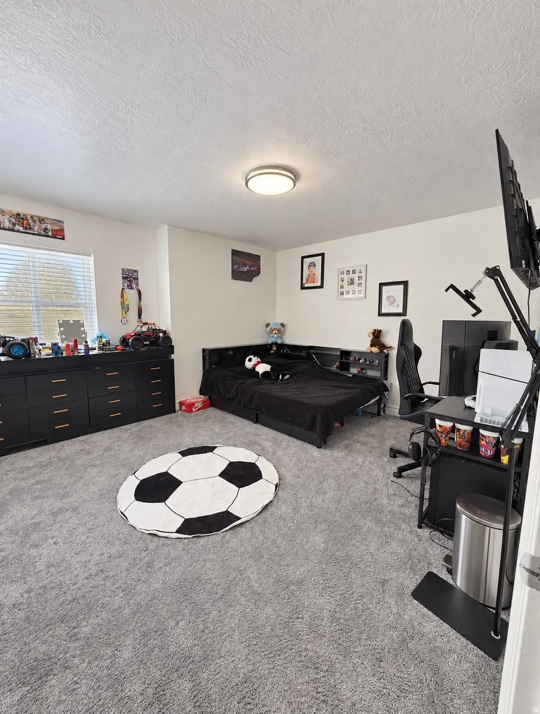Recessed lighting, light gray carpeting, and a built-in window with horizontal blinds