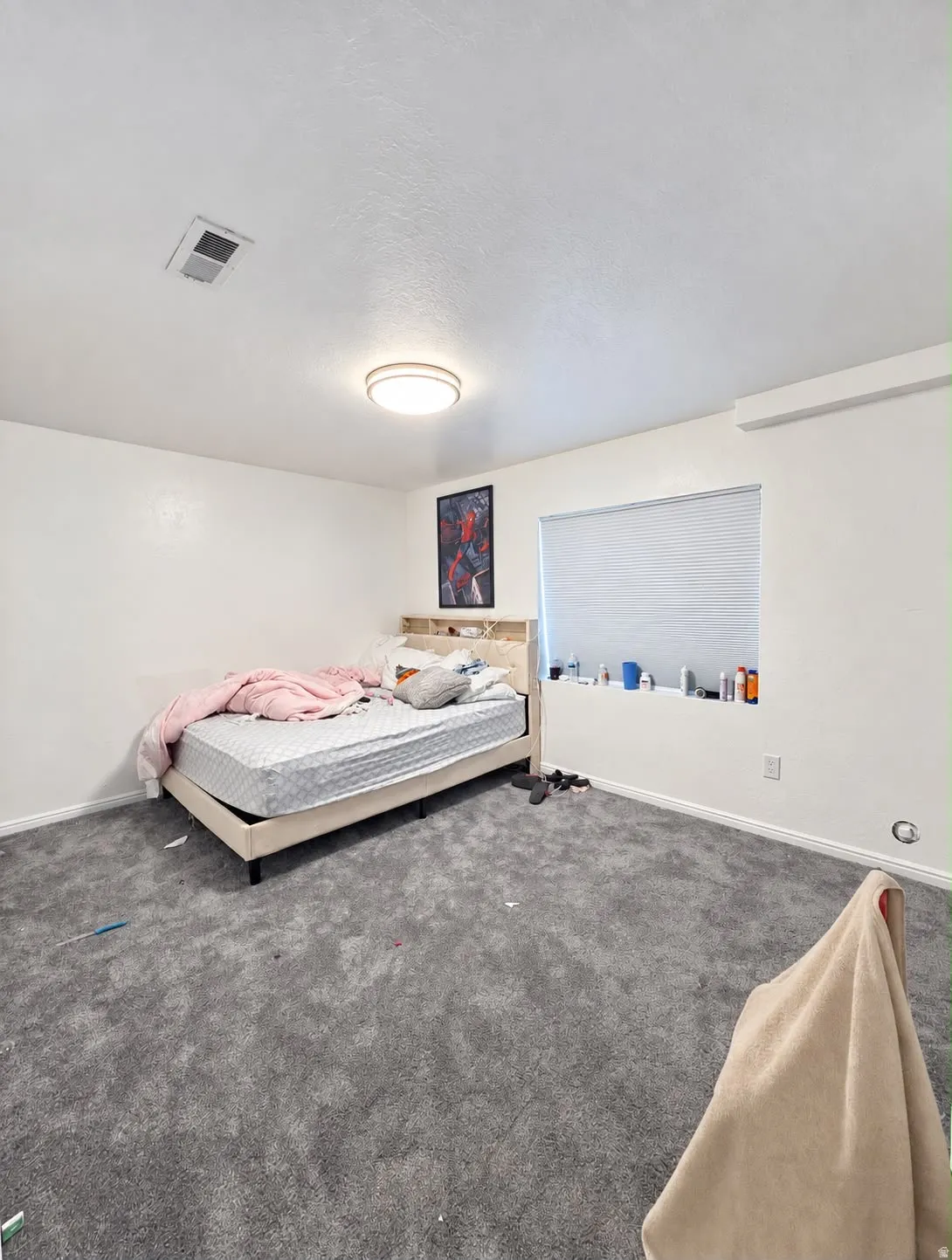 Spacious secondary bedroom featuring neutral wall finishes, gray carpet flooring, recessed ceiling lighting, and a large window with cellular shades