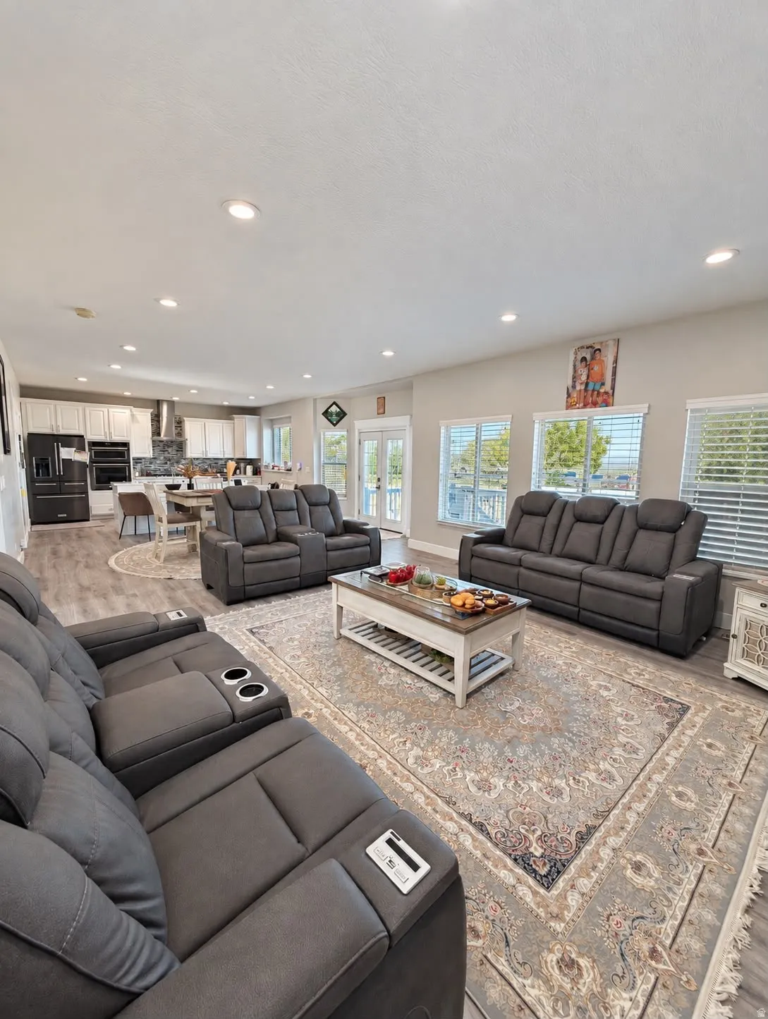 Open-concept living area with recessed lighting, wood-finish flooring, and multiple windows