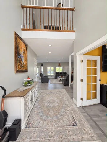 Two-story foyer with an open balustrade, recessed lighting, and wood-finish flooring