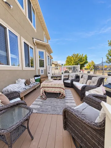 Expansive outdoor deck featuring wood-finish decking, white railings, and a built-in wooden bench