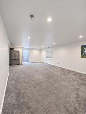 Spacious room with recessed lighting, light gray carpeting, and white walls