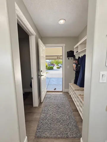 Entryway featuring wood-finish flooring, recessed lighting, and a built-in storage bench with shelving