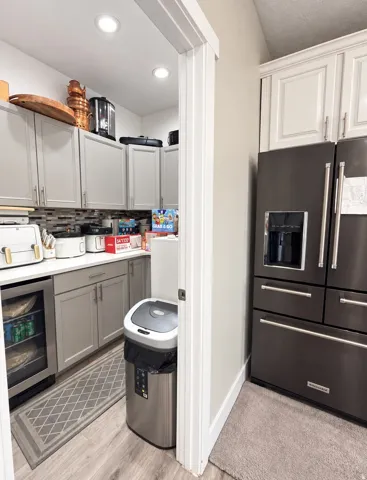 Kitchen pantry with recessed lighting, wood-finish flooring, and built-in beverage refrigerator