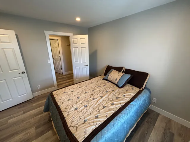 Wood-finish flooring, recessed lighting, neutral wall tones, and white trim
