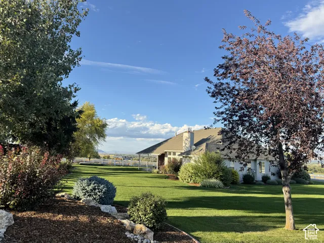 Expansive lawn featuring mature trees and established landscaping