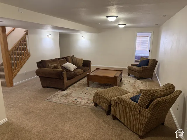 Spacious living area featuring neutral carpeting and recessed lighting
