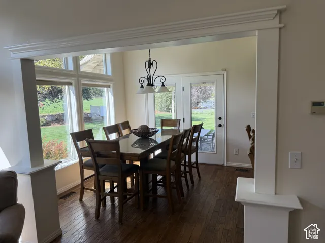 Archway with crown molding details, large windows, wood-finish flooring, and French doors