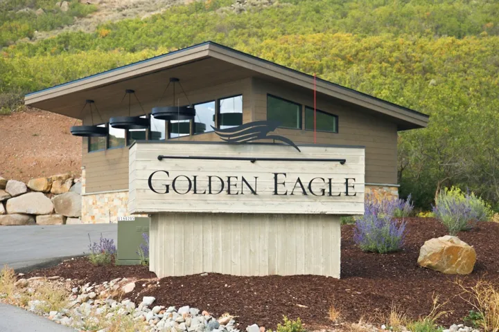 Curb appeal featuring a modern entry structure with a sloped roofline, horizontal siding, and stone accents