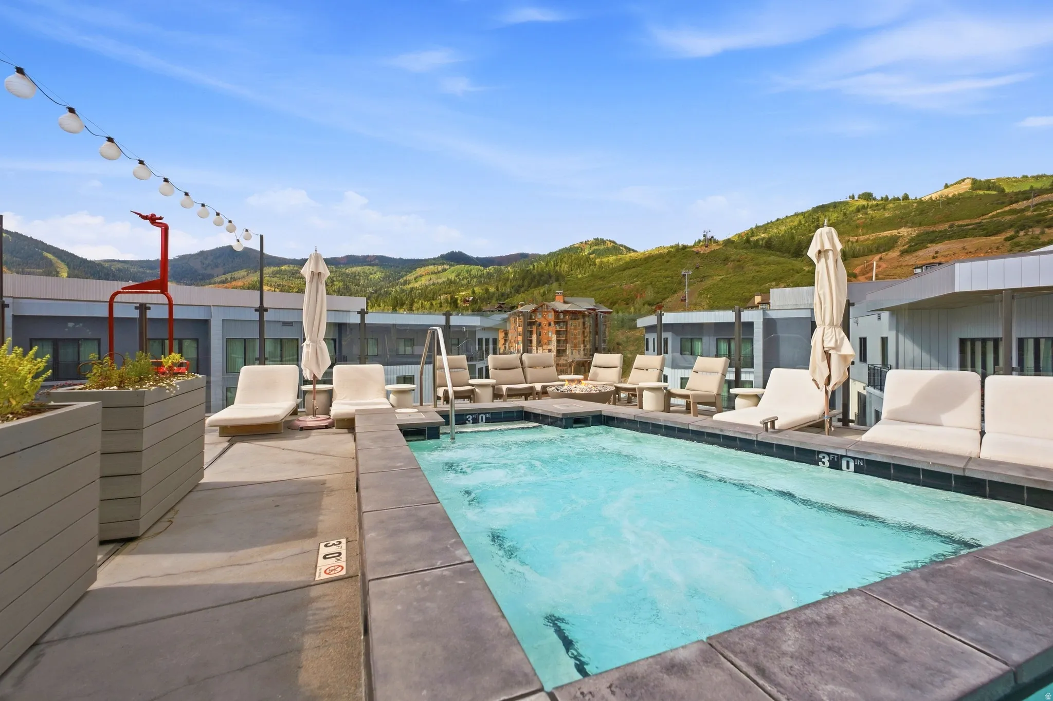 Rooftop pool with integrated spa and concrete coping, surrounded by a concrete deck