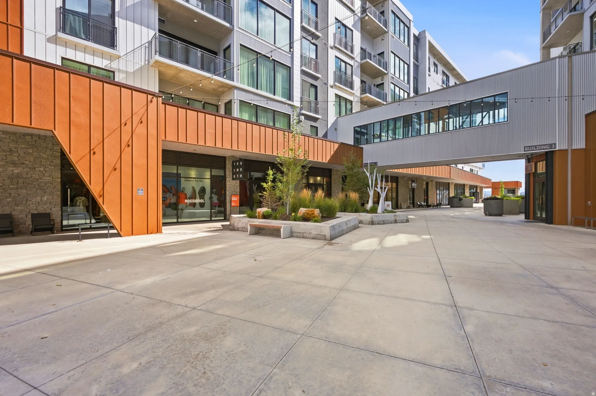 Modern building exterior with metal paneling, stone accents, and expansive windows