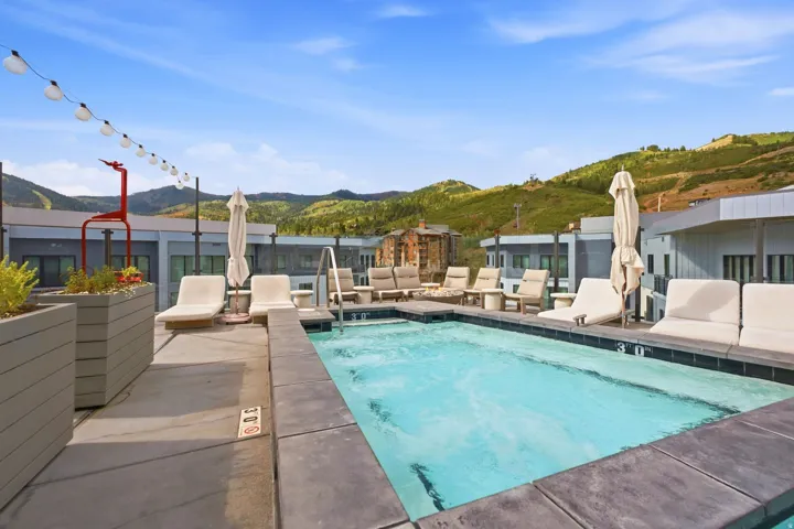 Rooftop pool with integrated spa and concrete coping, surrounded by a concrete deck