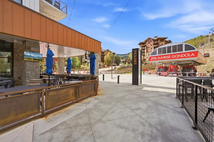 Outdoor dining area featuring a stone column and a copper-toned awning