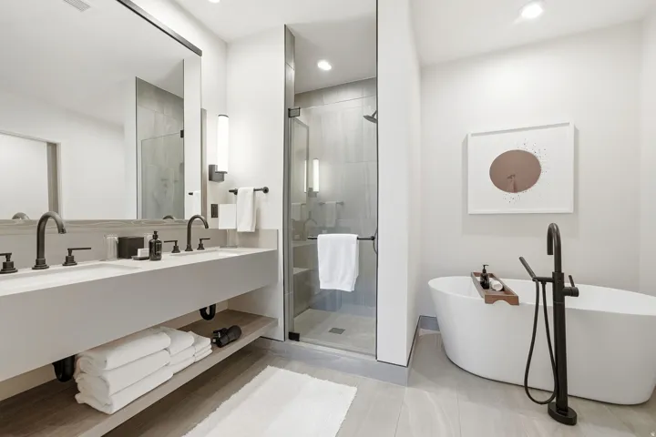 Dual vanity with matte black fixtures, an expansive mirror, and integrated lighting