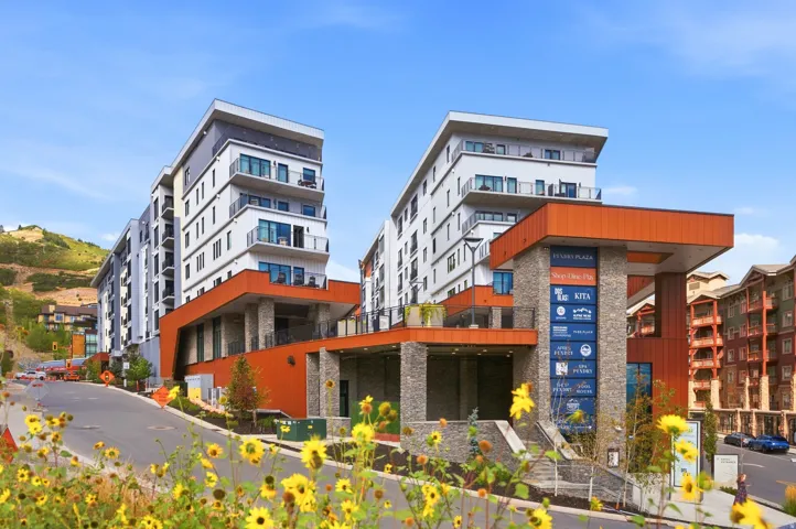 Modern multi-story building featuring stacked stone and wood-finish exterior accents