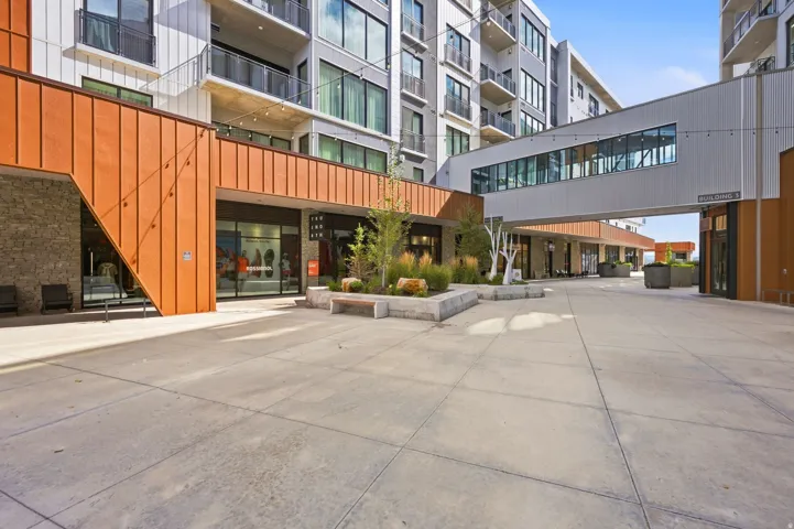 Modern building exterior with metal paneling, stone accents, and expansive windows