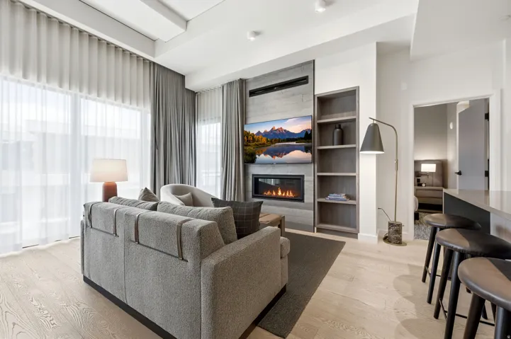 Integrated media wall with an electric fireplace, built-in shelving, and light wood-finish flooring