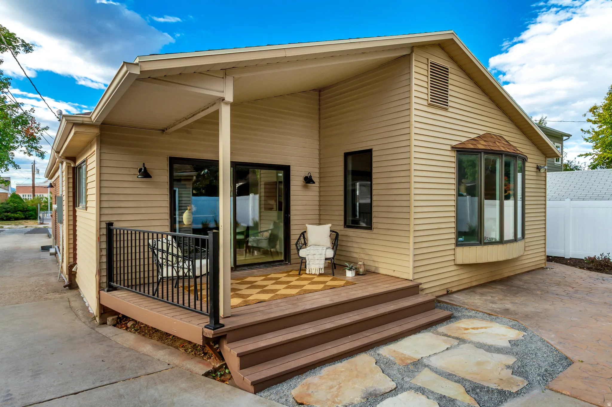Exterior siding with a covered patio and black metal railing