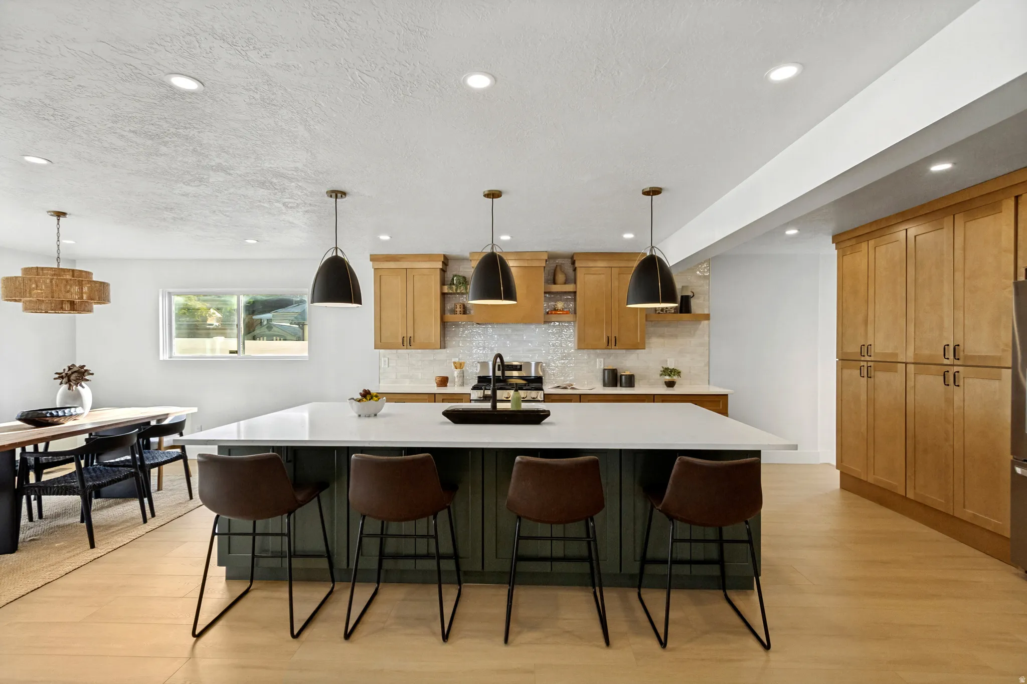 Kitchen with a large island featuring a white countertop and dark green base