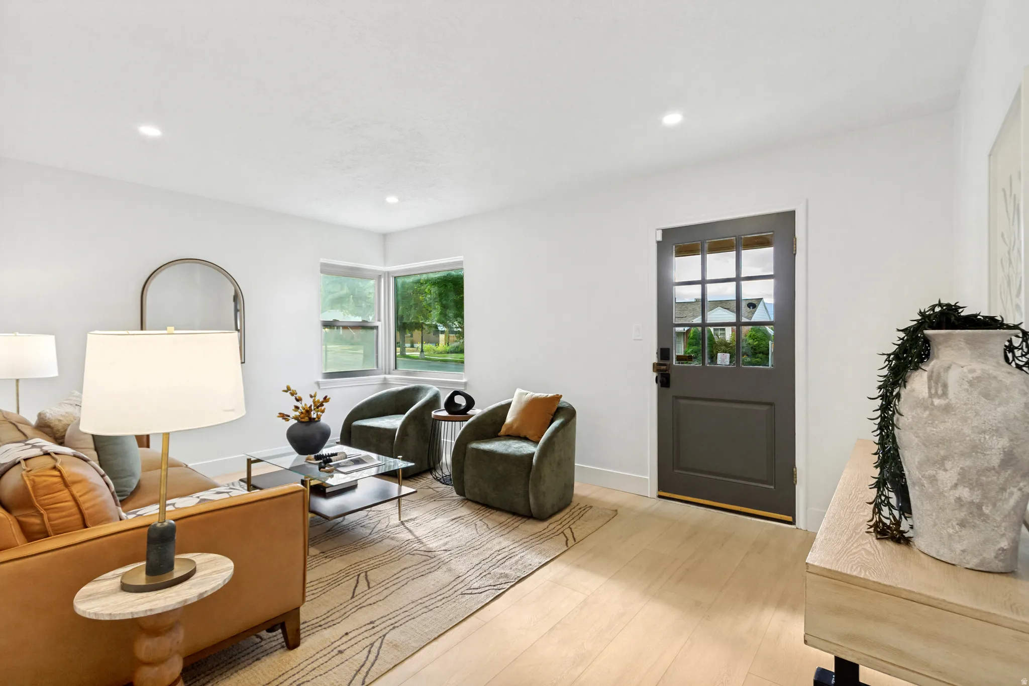 Light wood-finish flooring, recessed lighting, and a multi-pane entry door