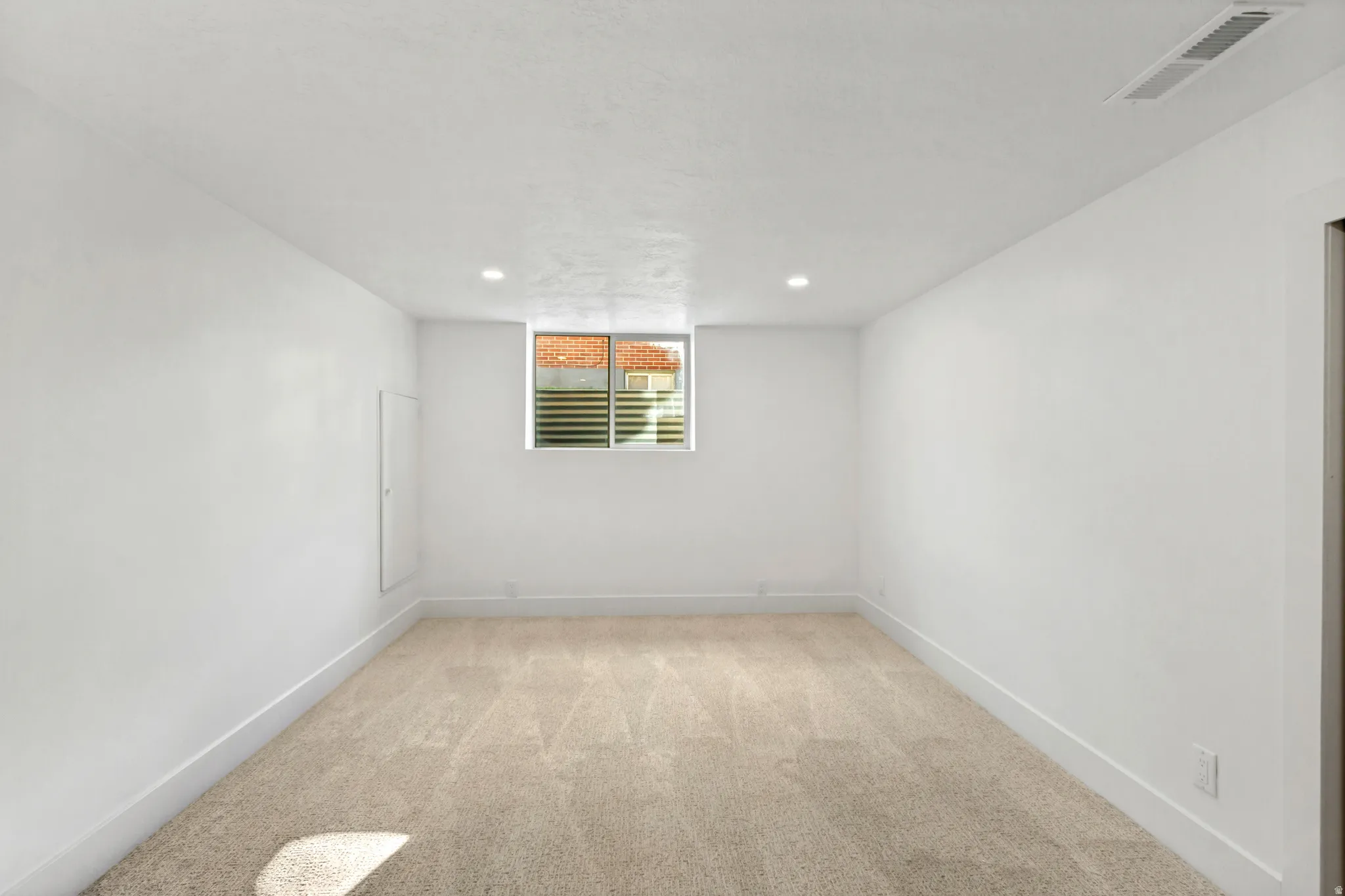 Recessed lighting, light-colored carpet, white walls, white trim, and a window with horizontal blinds