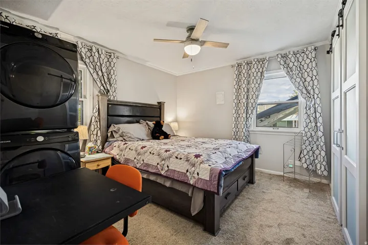 Built-in laundry appliances, ceiling fan with integrated lighting, window with trim, and light-colored carpeting