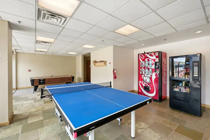 Recreational space with stone tile flooring, drop ceiling, recessed lighting, and neutral wall paint