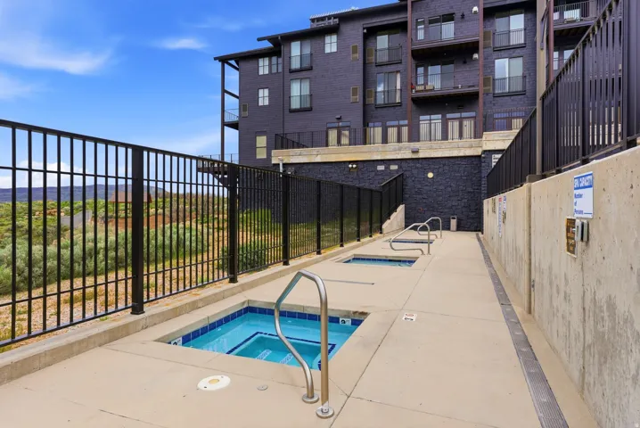 Outdoor spa area with multiple in-ground spas, concrete decking, and metal railings