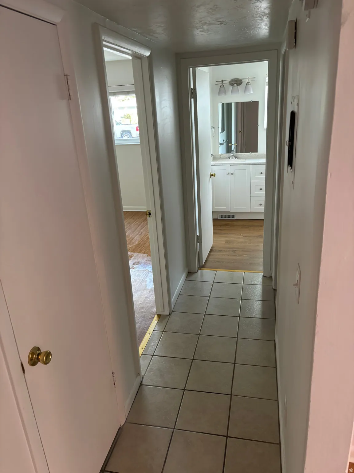 Tile flooring in a neutral tone, white walls, and bright overhead lighting