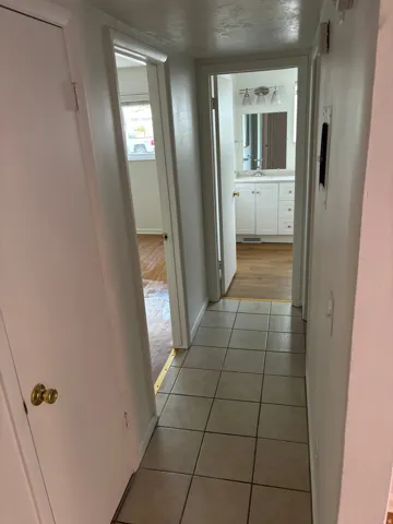 Tile flooring in a neutral tone, white walls, and bright overhead lighting