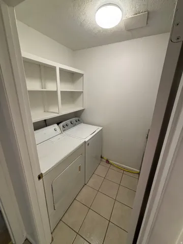 Built-in white shelving, tile flooring, and overhead lighting