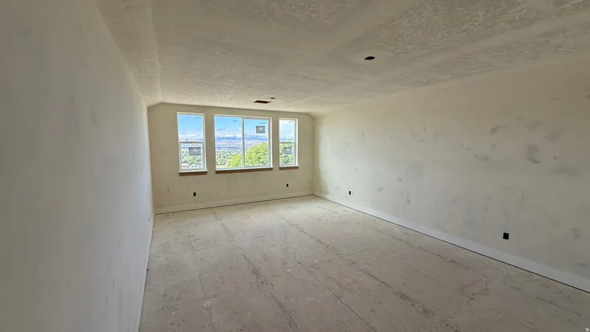 Multiple windows, high ceilings, unfinished walls, unfinished flooring