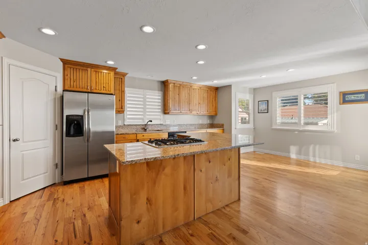 Kitchen featuring wood-finish flooring, recessed lighting, and a center island with a gas cooktop