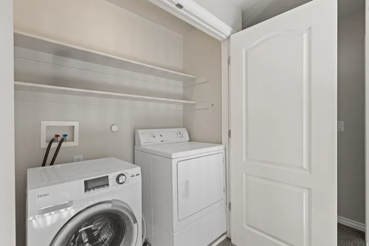 Laundry area with integrated shelving and included washer and dryer appliances