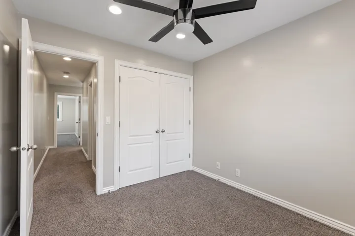 Recessed lighting and ceiling fan in room