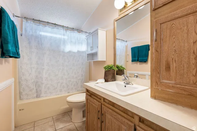Bathroom featuring a single vanity, wood-finish cabinetry, built-in mirror, overhead lighting, and a bathtub with shower