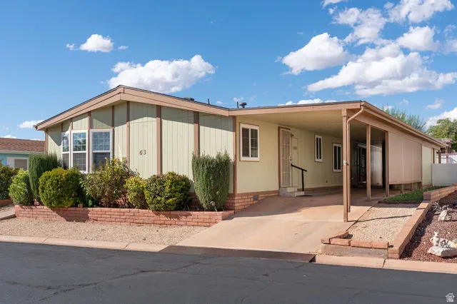 Siding exterior with a bay window, concrete driveway, and covered carport