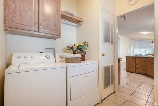 Laundry area featuring wood-finish cabinetry, a built-in shelf, and tile flooring
