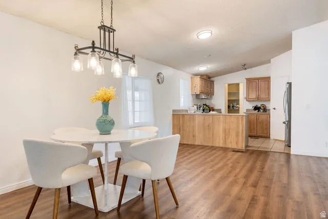 Wood-finish flooring throughout, with a dining area featuring a linear chandelier