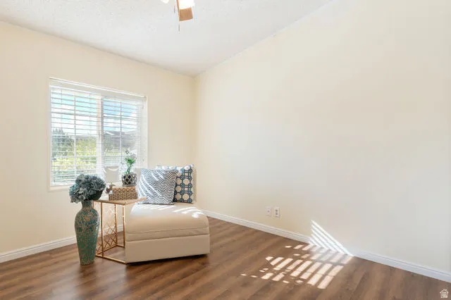 Window with horizontal blinds, wood-finish flooring, ceiling fan, and light-toned wall paint