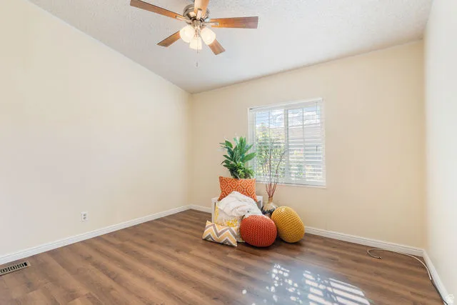 Wood-finish flooring, white trim, a ceiling fan with integrated lighting, and a white-framed window with blinds