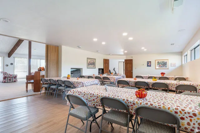 Expansive open space with wood-finish flooring, recessed lighting, and multiple windows