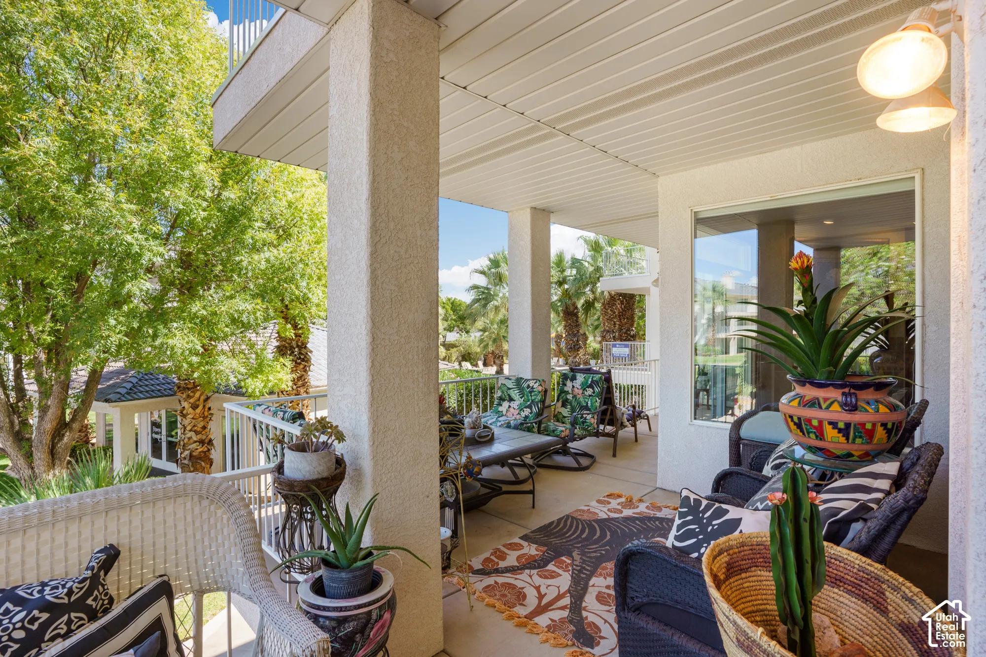 Covered outdoor patio with a concrete surface, white columns, and a white railing