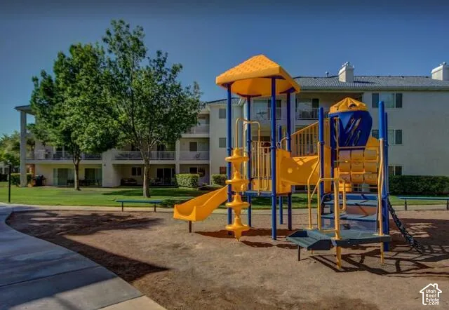 Community playground featuring multiple slides, climbing structures, and a shaded platform