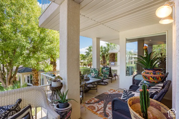Covered outdoor patio with a concrete surface, white columns, and a white railing