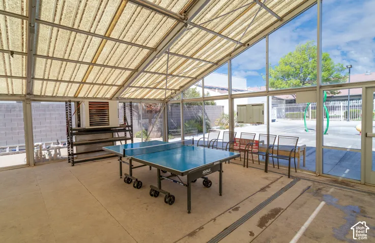 Enclosed covered lap pool  with Ping Pong table, 2 Hot tubs, and a translucent sloped roof and concrete flooring