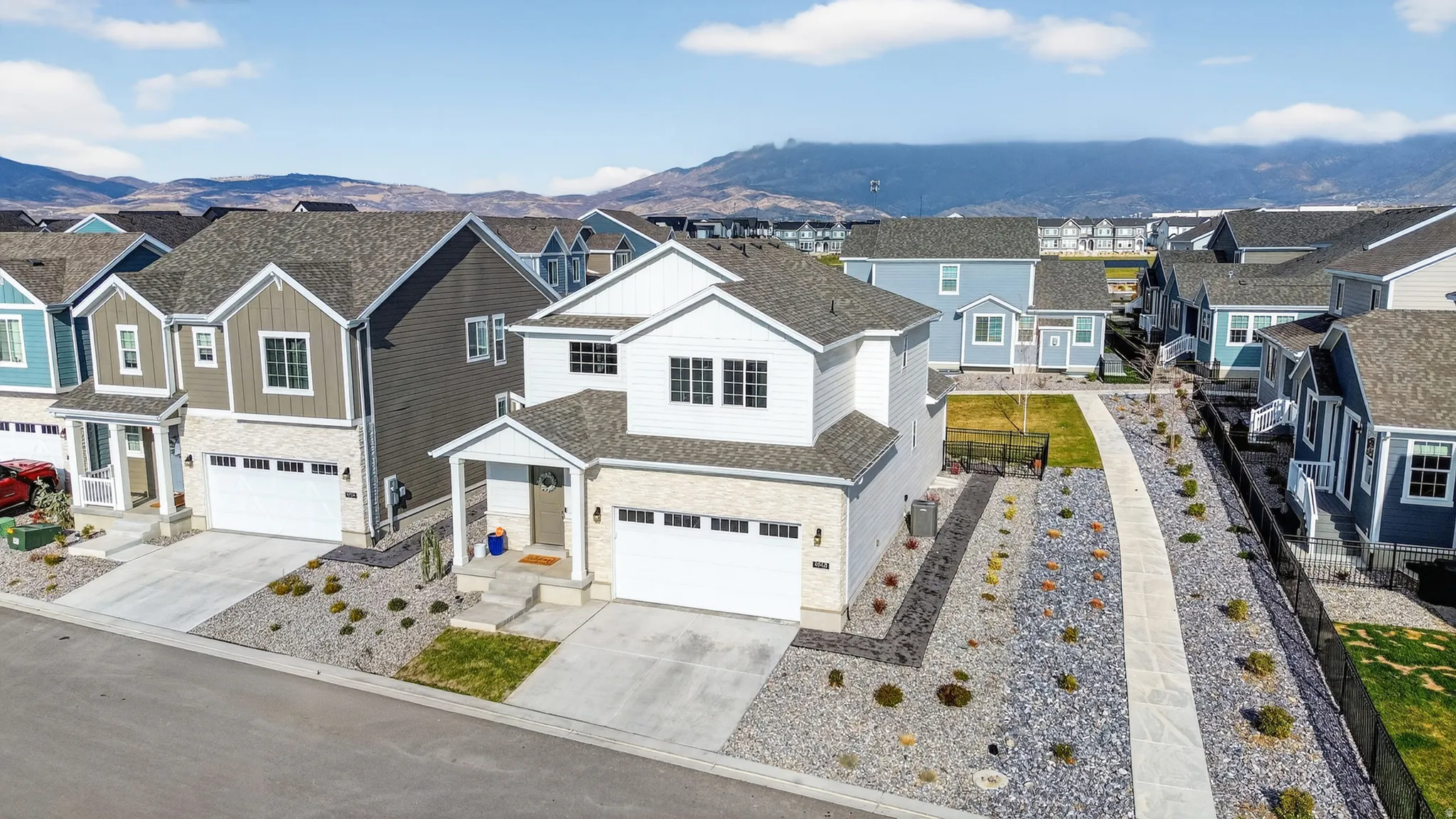 Modern two-story residence featuring a two-car garage, stone and siding exterior, and a covered entry