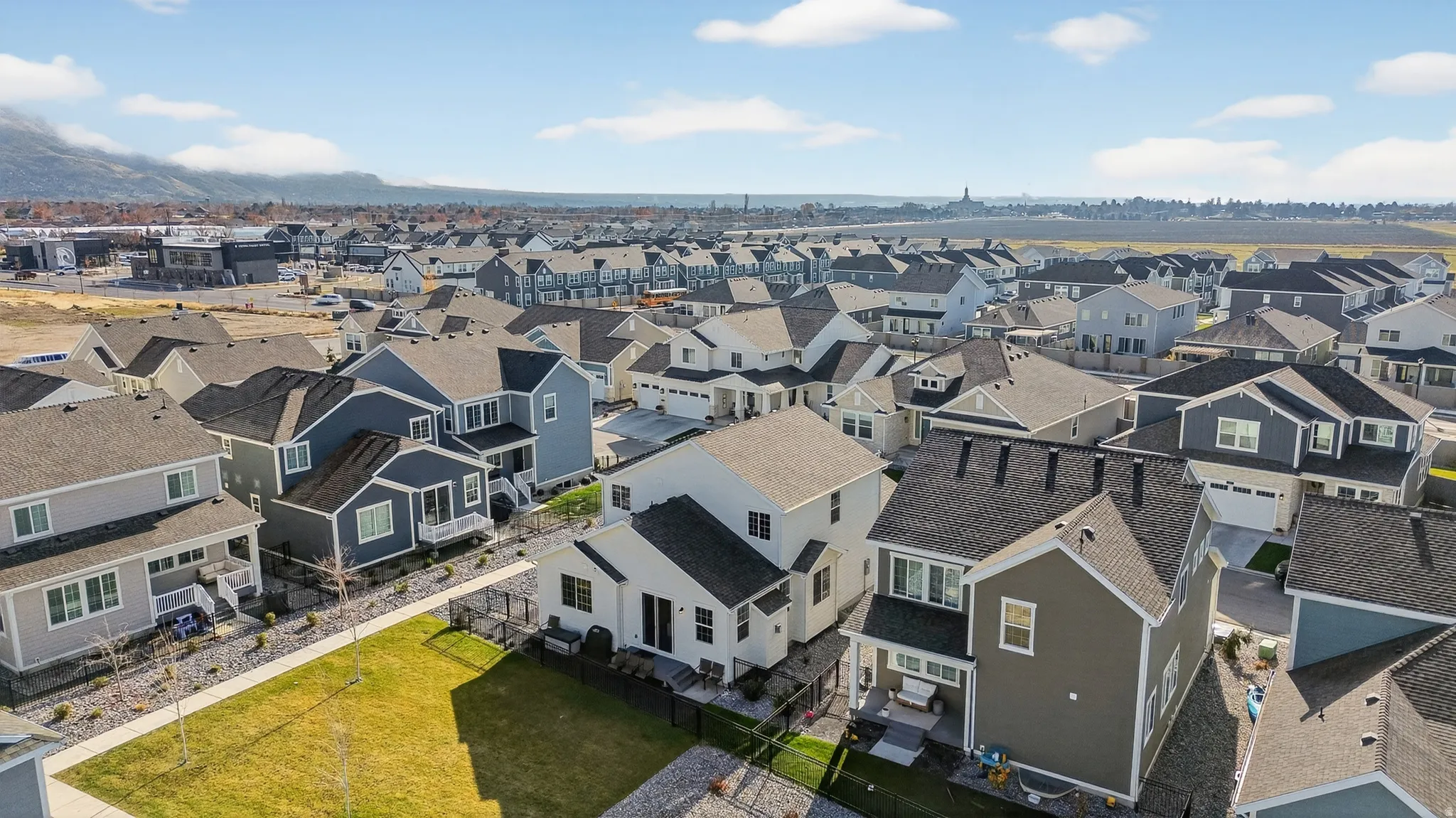 Residential community with consistent architectural styles, varied exterior colors, detached homes, attached garages, and fenced yards